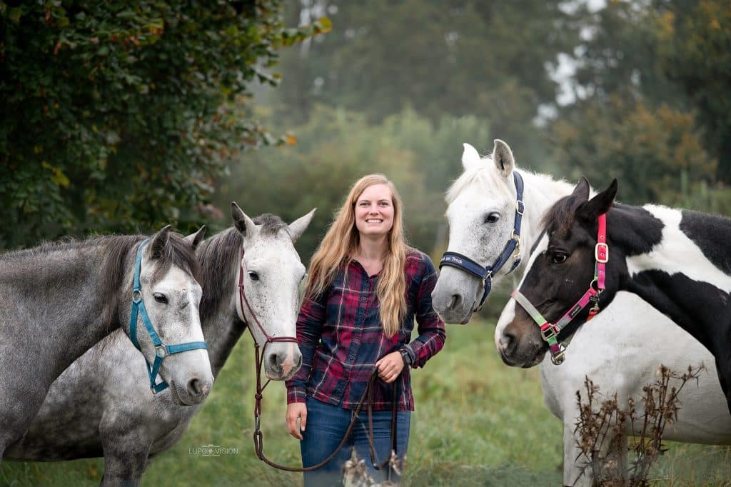 Junge Frau mit einer Gruppe Ponys bei einem Pferdefotoshooting